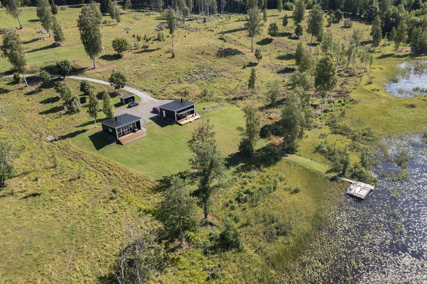 The grounds with the two cabins, the lawn and the private jetty by the lake
